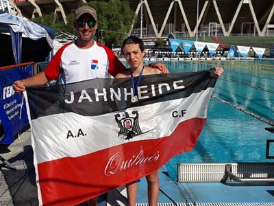 Mati Armida y su entrenador, en la pileta cordobesa y con la bandera de la AACFQ.