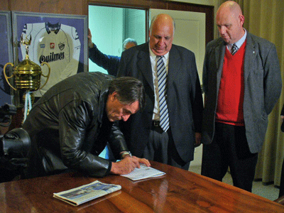 Tocalli pone la firma, ante la mirada atenta del presidente Coloma.