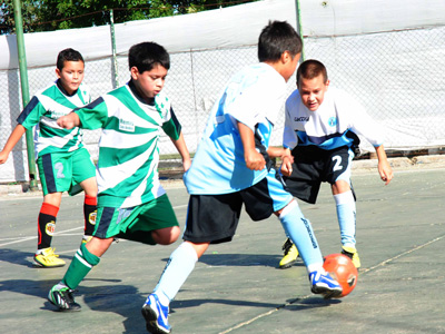 Los chicos se divierten en el torneo de verano de fútbol pista.