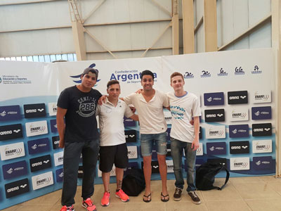 Los tres nadadores del Social Don Bosco, junto al entrenador.